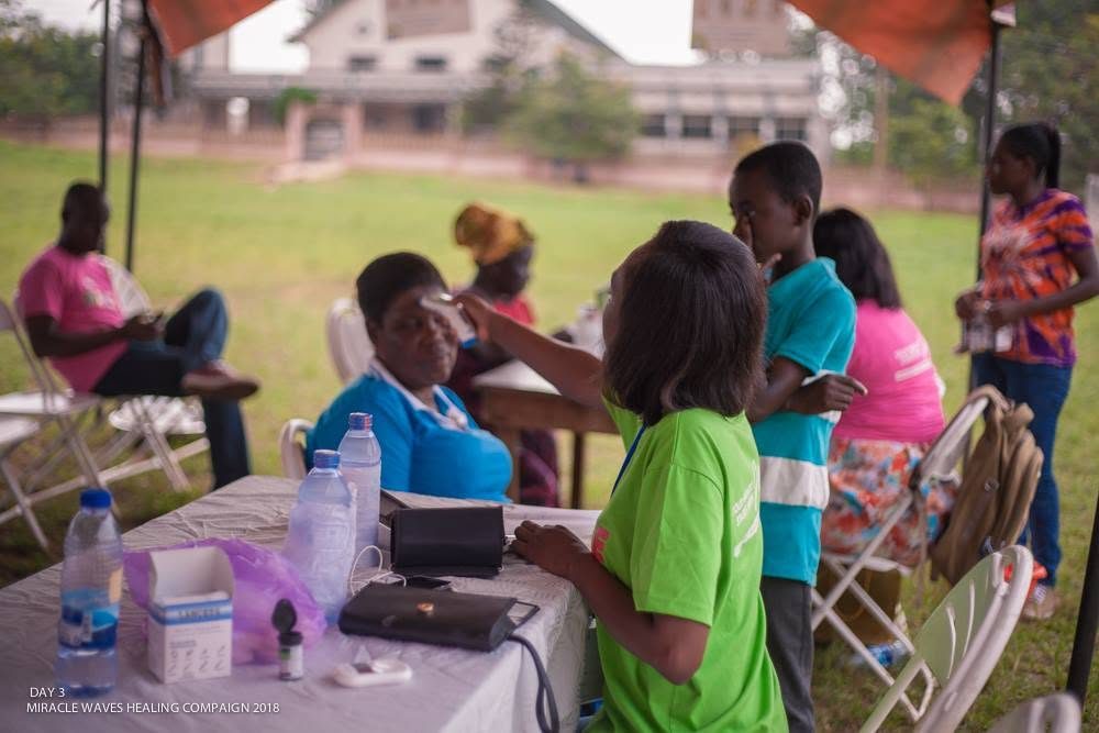 A campaign clinic table with blood-pressure equipment and supplies